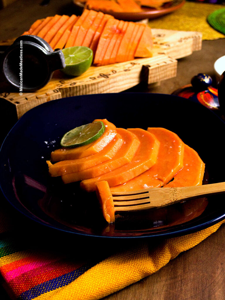 Sliced papaya on a blue plate after showing how to clean papaya.