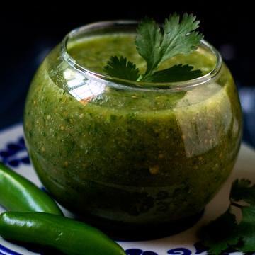 Small glass cup filled with homemade salsa verde inside.