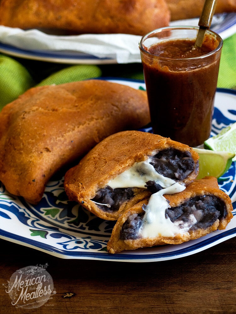 Black bean and Oaxaca cheese empanadas on a blue and white plate. 