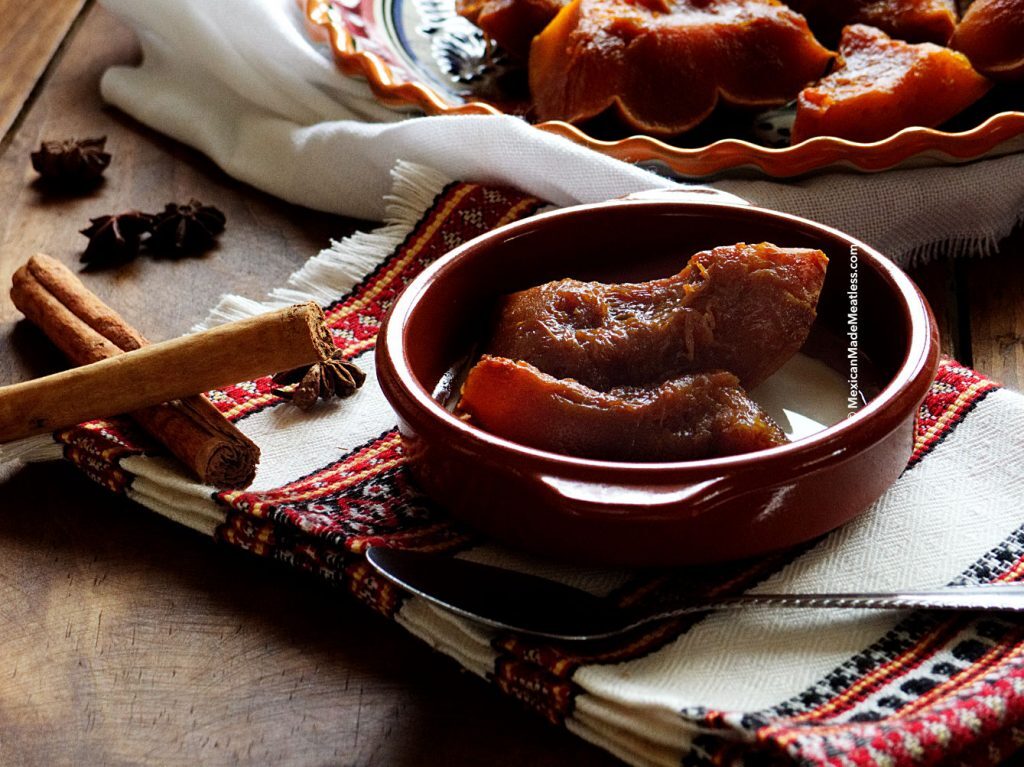 A terracotta bowl filled with Mexican candied pumpkin and evaporated milk. 