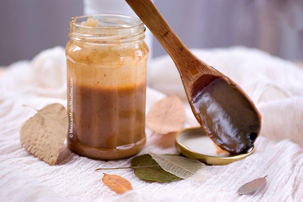 Glass jar half filled with cajeta or Mexican caramel sauce sometimes also called dulce de leche.