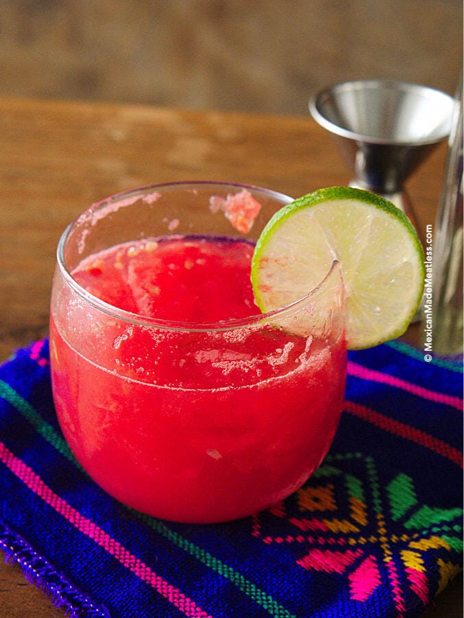One serving watermelon and tequila cocktail with a lime slice garnish.