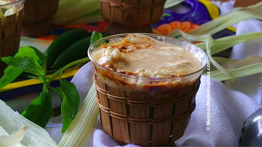 Small glass filled with Mexican corn in a cup.