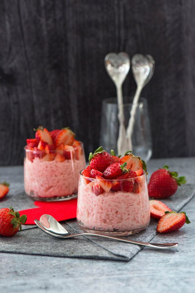 Strawberry arroz con leche topped with fresh strawberries. 