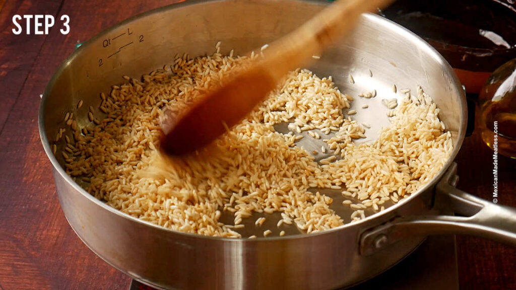 Sautéing long grain rice in a stainless steal pan to make Mexican arroz rojo.