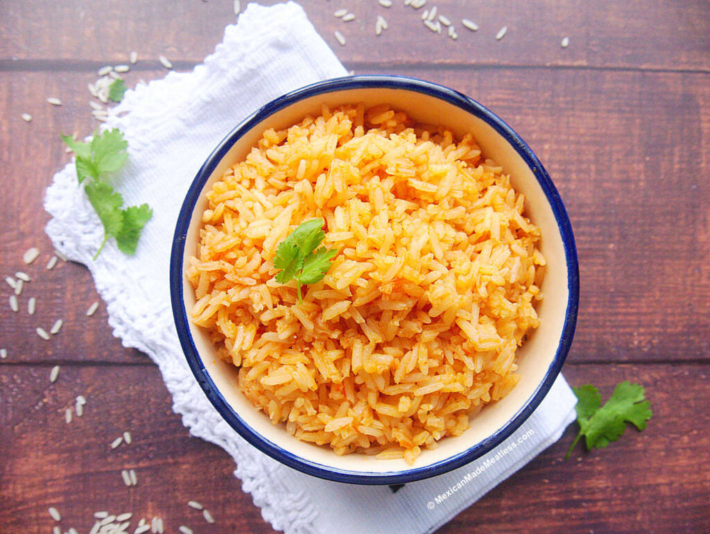 Bowl full of Mexican rice made with tomato sauce.