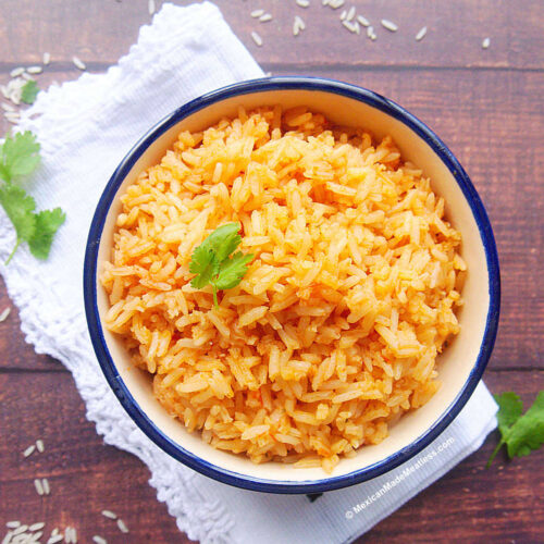 Bowl full of Mexican rice made with tomato sauce.