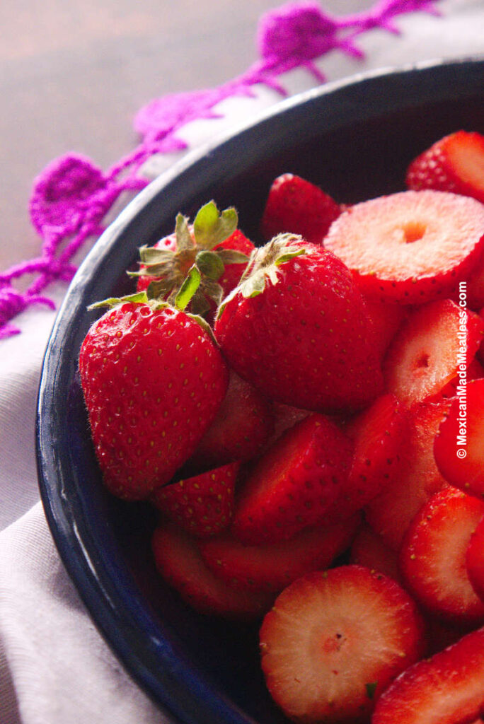 A blue bowl filled with fresh juicy strawberries.