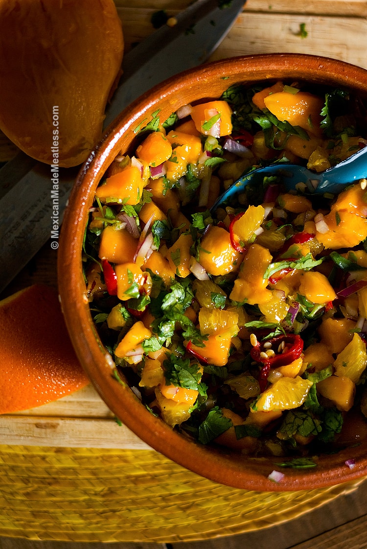 Bowl filled with chunky mango and orange salsa.