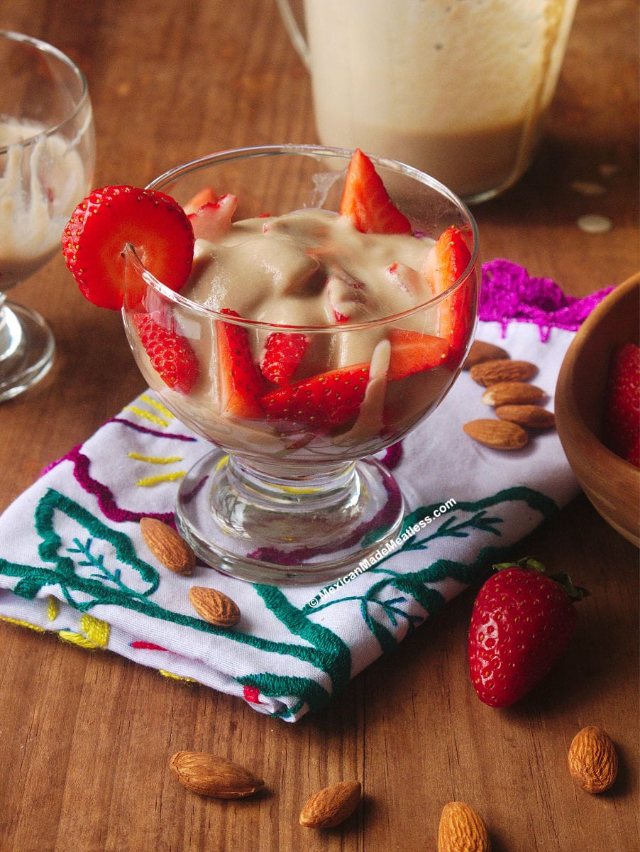 Dessert glass full of strawberries and sweet almond cream.