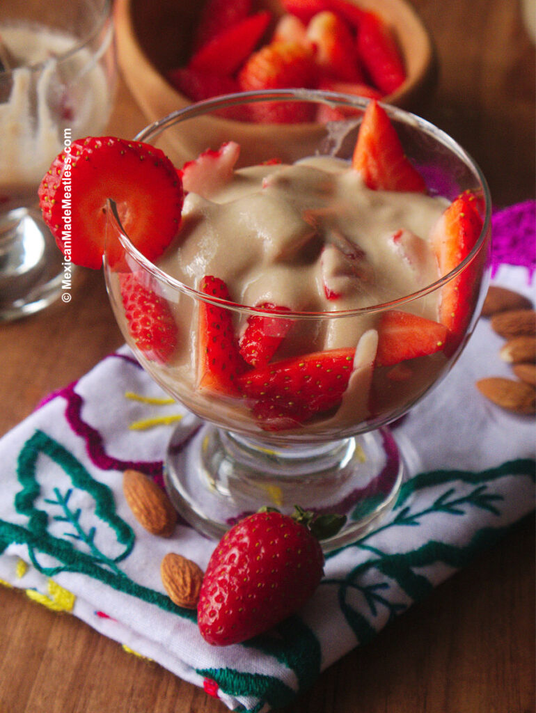 Dessert cup filled with sweet and juicy quartered strawberries drizzled with vegan sweet cream.