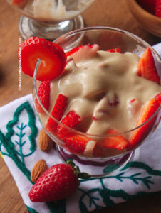 Dessert cup filled with sweet and juicy quartered strawberries drizzled with vegan sweet cream.