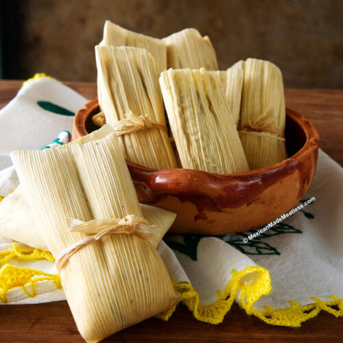 Uncooked tamales inside a Mexican bowl.