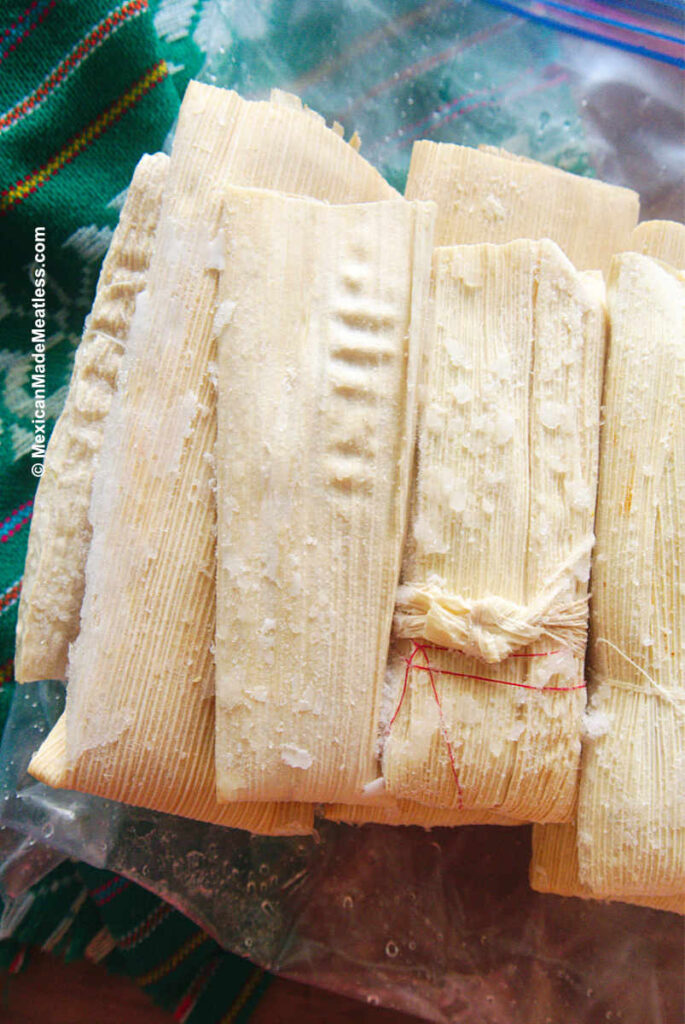 Frozen tamales with some ice crystals on them. 