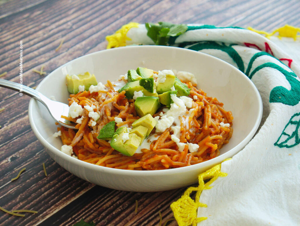 A white bowl with Mexican Fideo Seco pasta dish cooked in a tomato chipotle sauce.