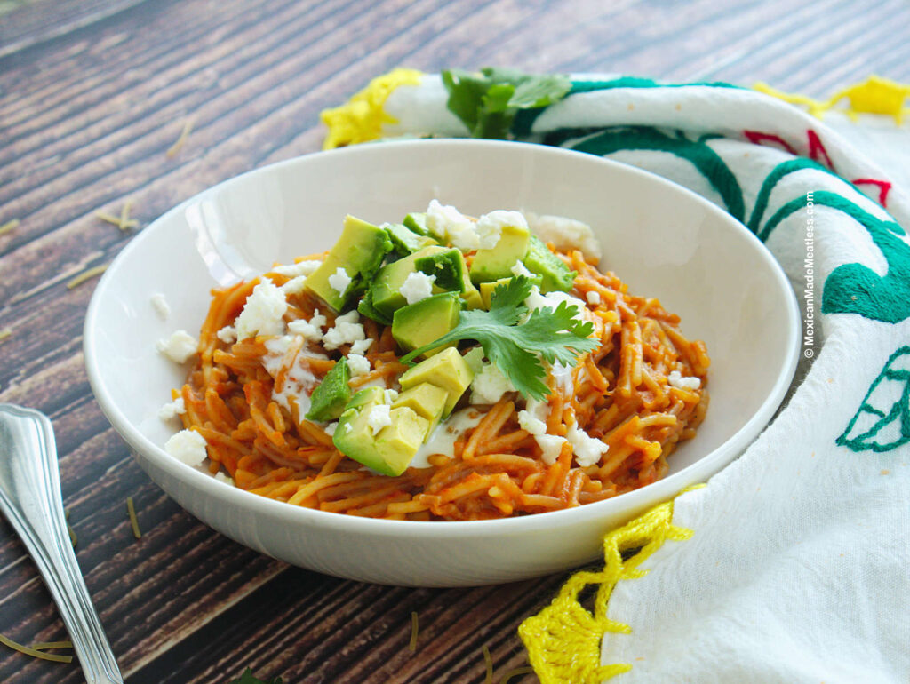 A white bowl with Mexican Fideo Seco pasta dish cooked in a tomato chipotle sauce.