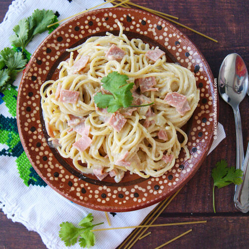 A plate with Mexican white cream spaghetti with ham but made vegan.