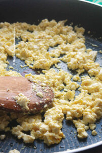 Cooking silken tofu with a little turmeric powder to make vegan scrambled eggs.