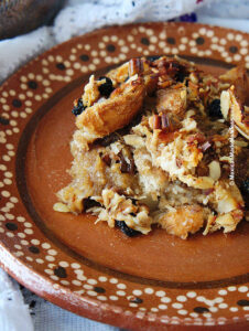Close up view of capirotada bread pudding made with pecans and almonds.