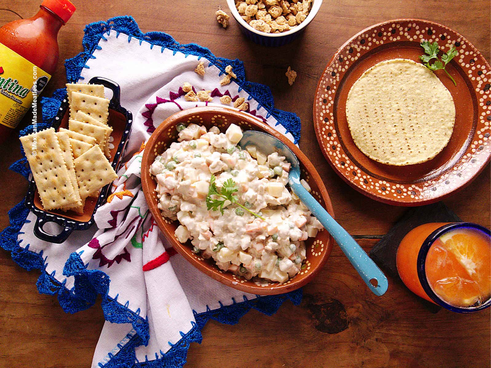 Mexican chicken salad made inside an earthenware bowl with tostada shells and saltine crackers on the side.