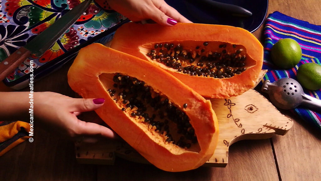 A slice papaya showing the dark black seeds inside.