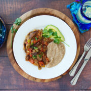 Bistec a la mexicana or Mexican style steak served with refried beans and avocado slices.