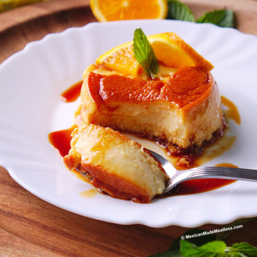Individual flan made with La Lechera and orange juice served on a small white plate with caramel sauce.