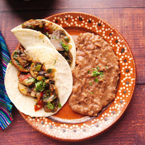 Sautéed Mexican mushrooms served as mushroom tacos and with refried beans.