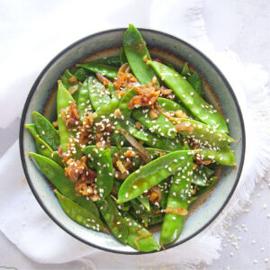 Small bow filled with sauteed garlic sesame snow peas.
