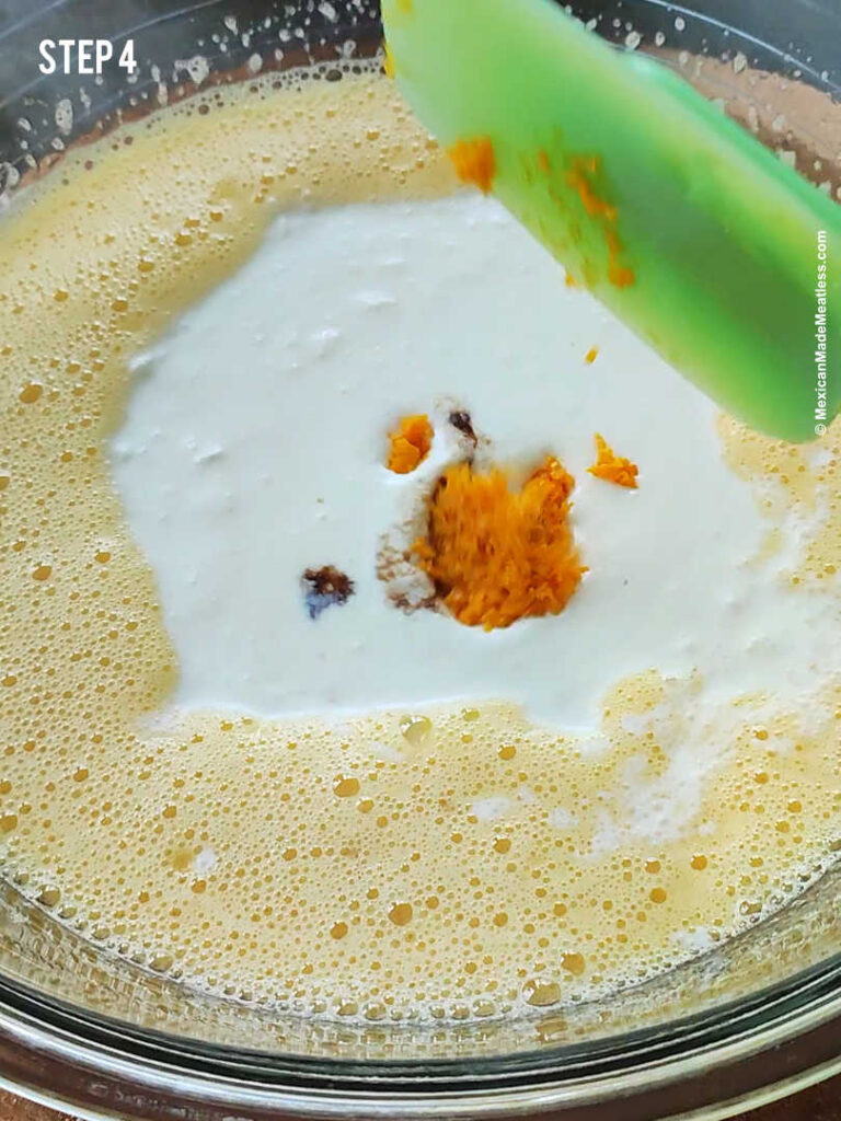 Mixing clotted cream, vanilla extract and orange zest into beaten eggs.