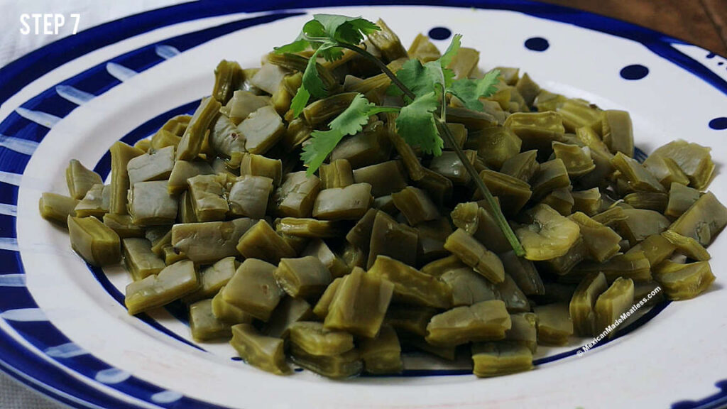 Cooked nopales on a white and blue plate.