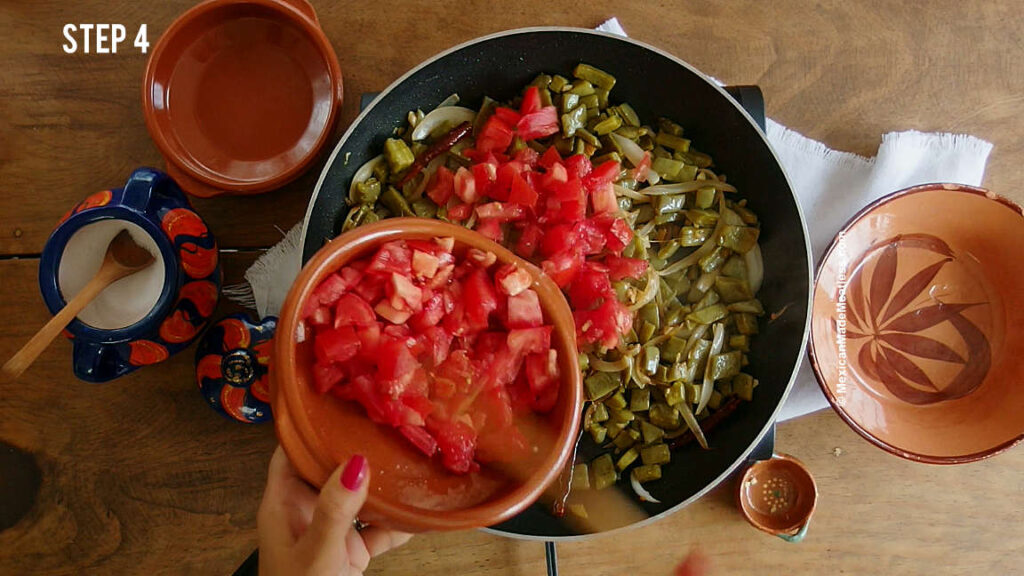 Cooking nopales a la mexicana in a large skillet. 