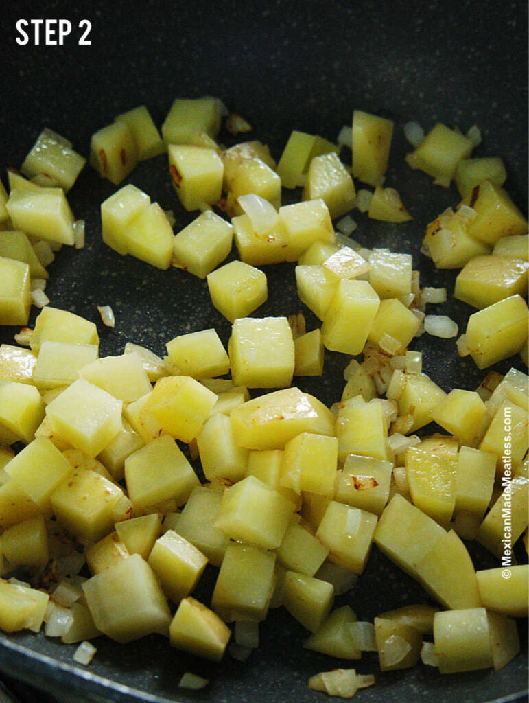Sauteing potato bits with onion to make Mexican papas con huevos.