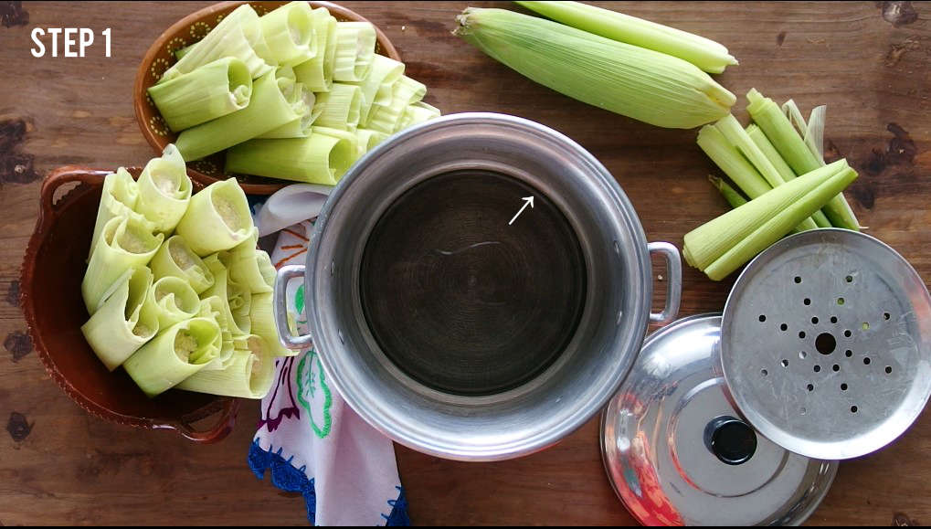 A Mexican tamale steamer pot called a tamalera filled with water to the indicated line for steaming tamales.