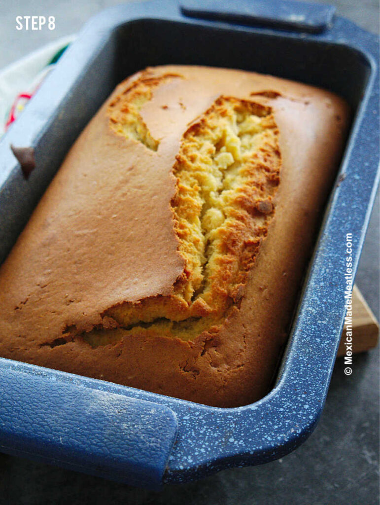 Cooling pound cake inside a blue loaf pan.