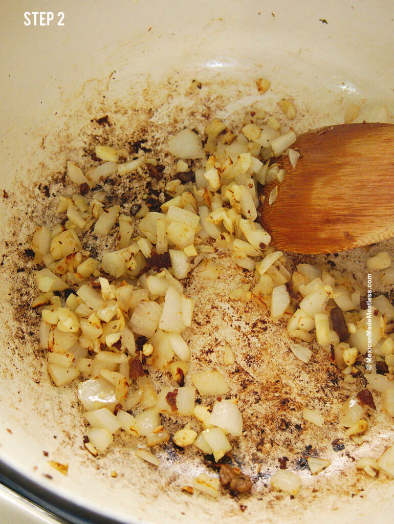 Sautéing onion and garlic in a large pot to make vegan caldo de res.