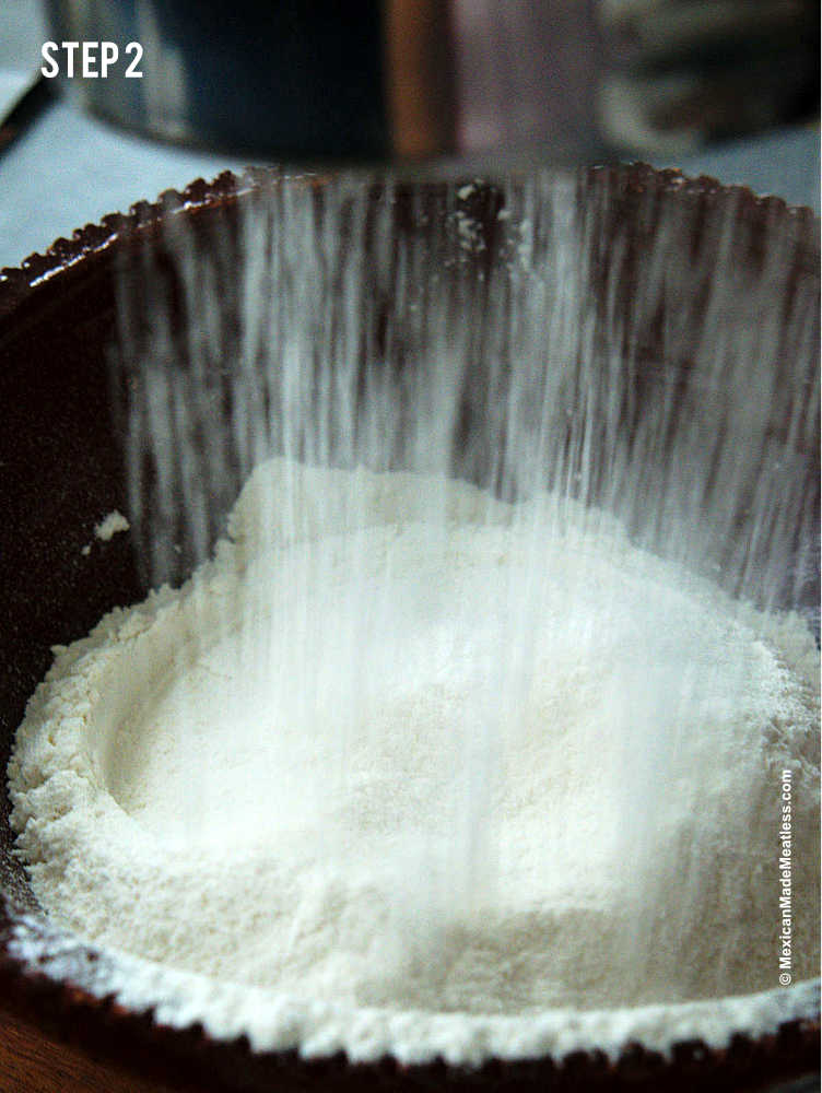 Sifting flour in a metal sifter to make Mexican pound cake.