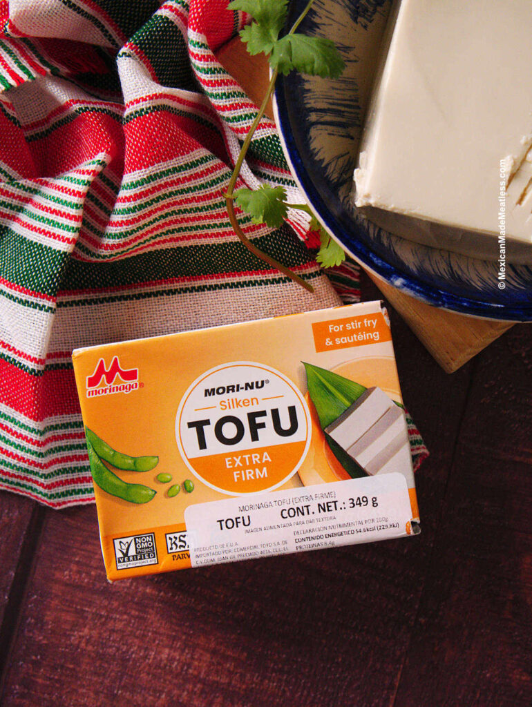A small box of silken tofu placed on a brown table.