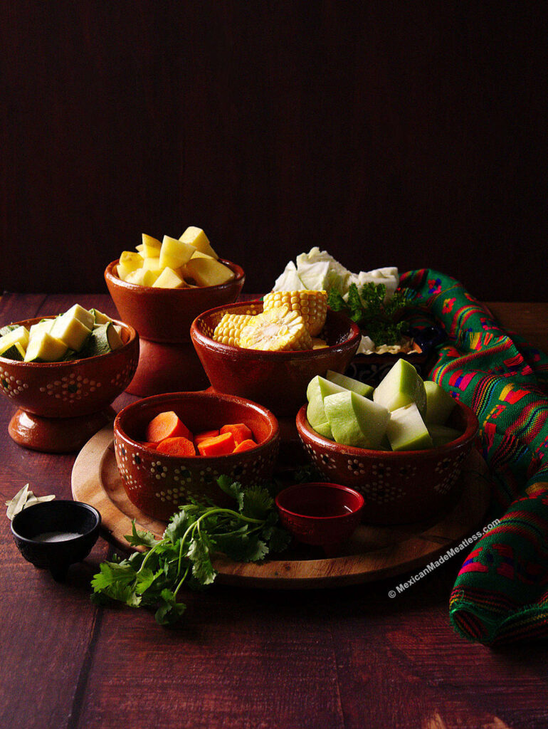 Small bowls filled with chopped vegetables used for making Mexican caldo de res.