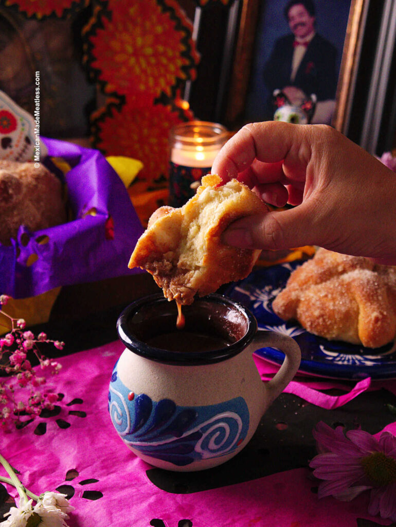 Dipping Day of the Dead pan dulce into a mug full of Mexican hot chocolate.