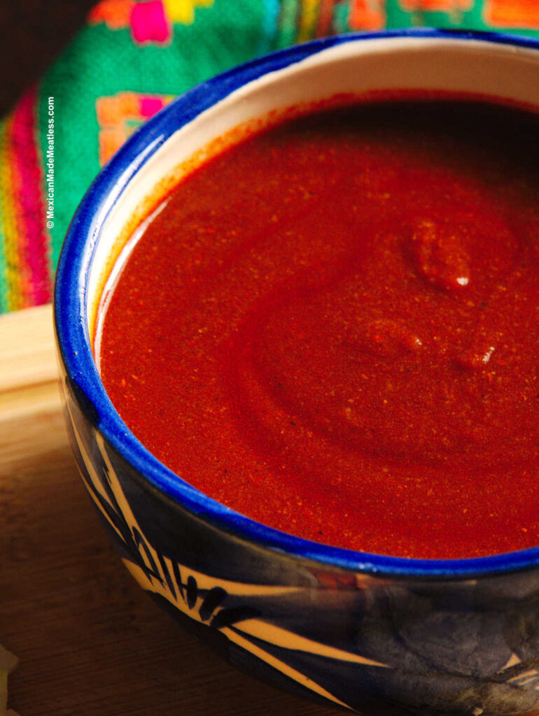 Red mole sauce inside a blue and white bowl.