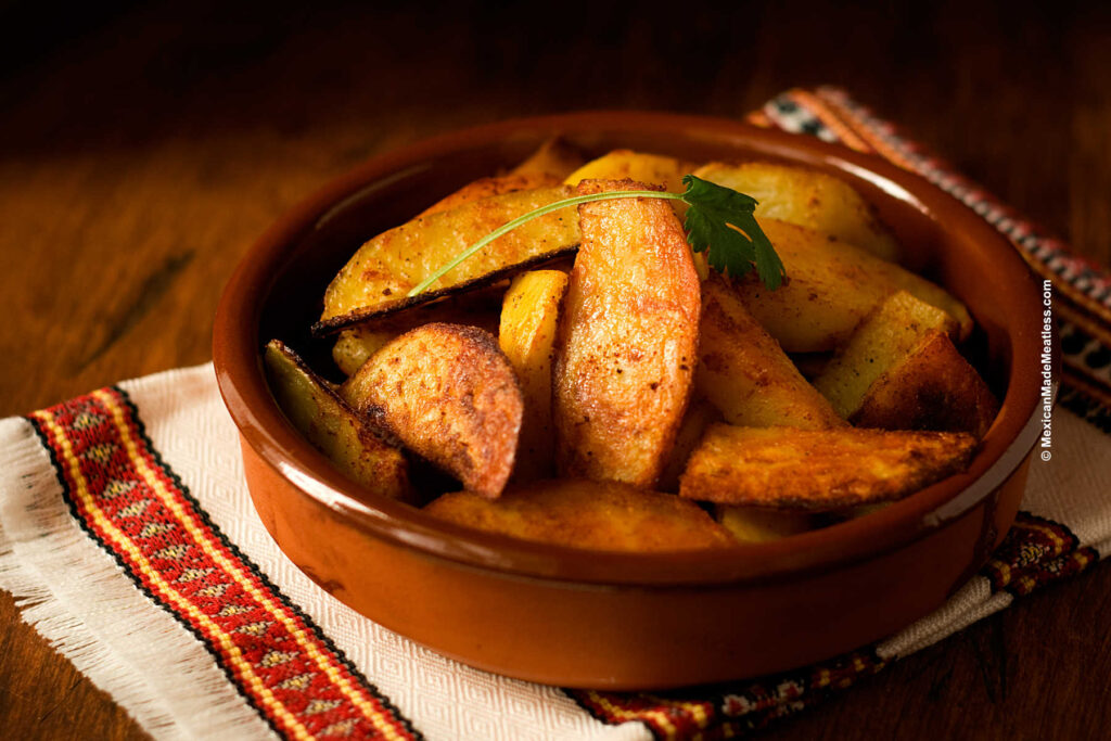 Roasted potatoes with Mexican spices served in a brown bowl. 