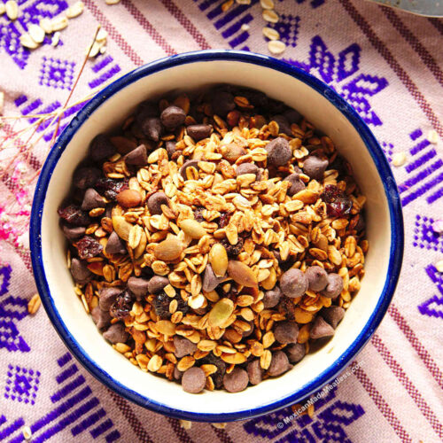 Small Mexican blue and white bowl filled with Mexican chocolate and pepita granola.
