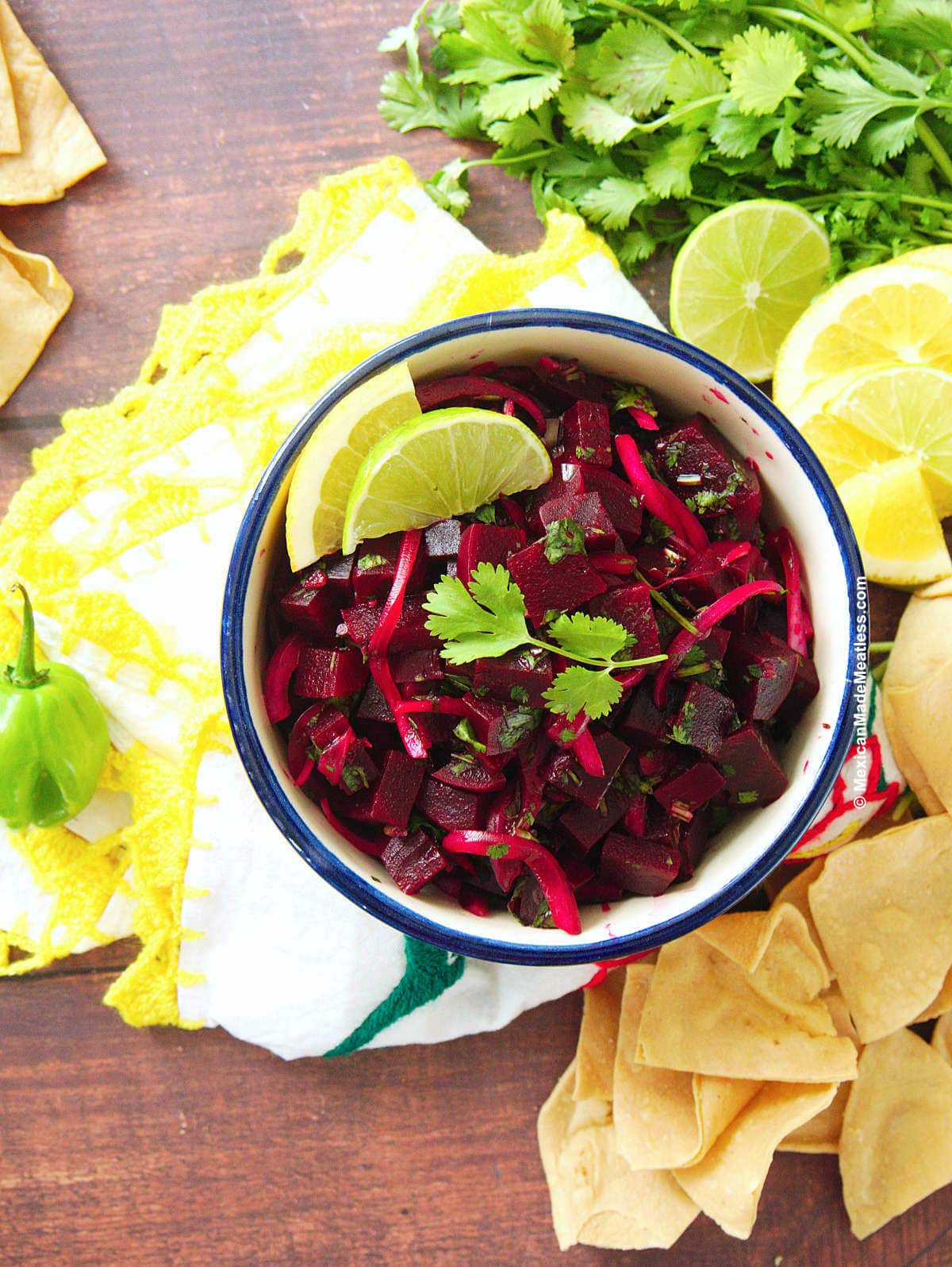 Yucatan-style beets prepared with orange juice, lime juice, red onions, cilantro and habanero pepper, served in a small white bowl.
