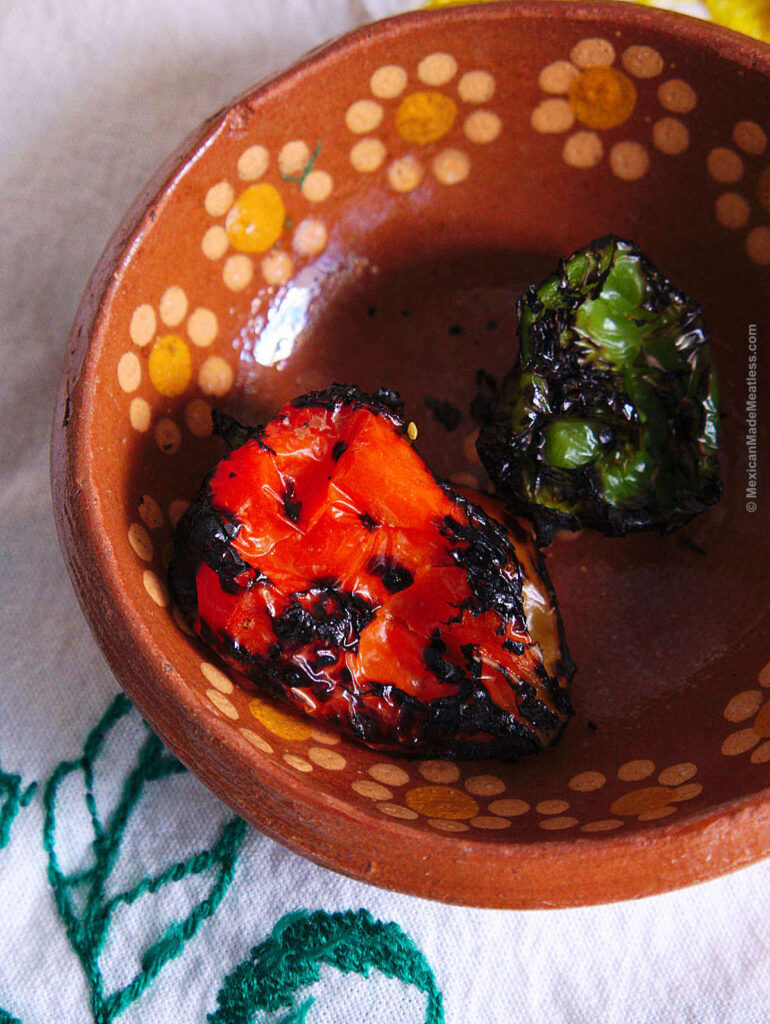 A red and green habanero peppers that have been blackened over an open flame. 