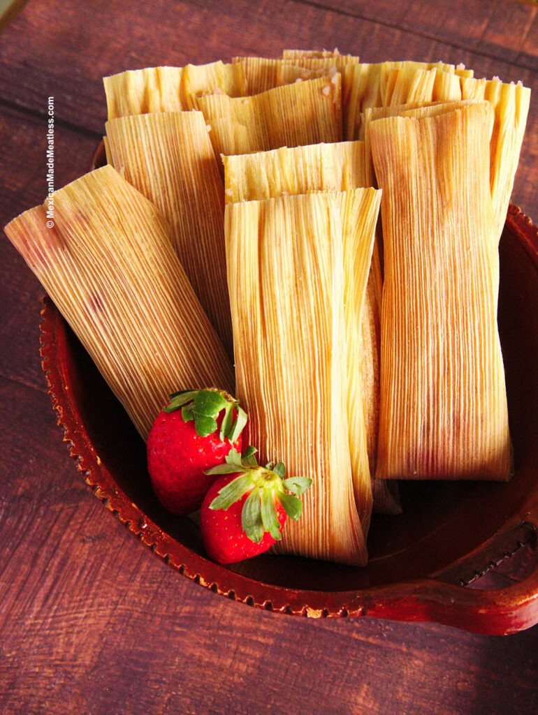 A small brown bowl filled with steamed strawberry tamales.