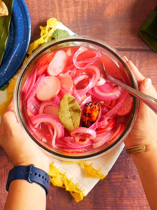 A glass bowl filled with pickled Mexican red onions.