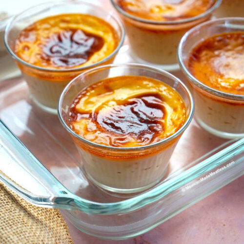 Jericallas or Mexican custard dessert inside small glass ramekins inside a glass baking dish.