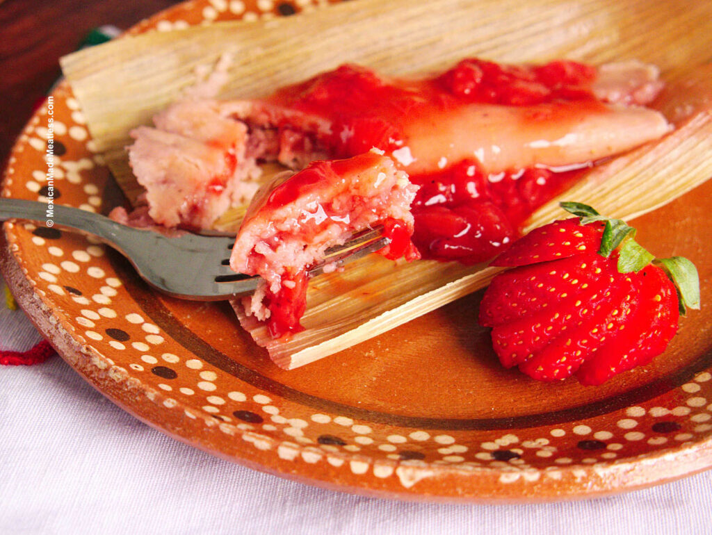 A close up view of a strawberry tamale filled and covered with strawberry jam.