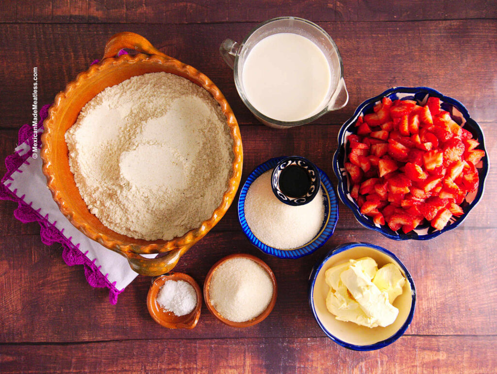 Ingredients for making strawberry tamales inside individual bowls. They are masa harina, milk, strawberries, sugar, butter, vanilla extract, baking powder and salt.